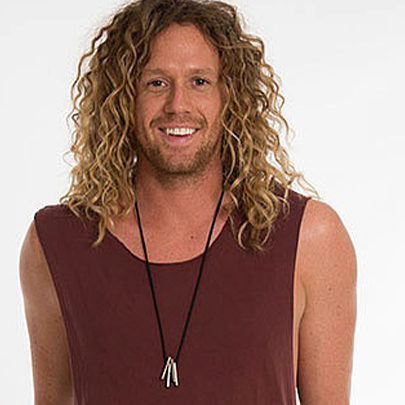 Photo of actor and Big Brother star Tim Dormer with long curly hair smiling mischievously at the camera